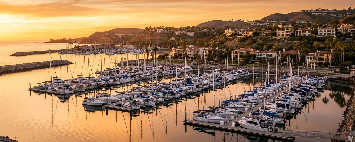 Buy a home in Dana Point CA — get 1% cash back at closing Dana Point harbor with sailboats and waterfront at sunset — Portfolio Home Realty buyer agent